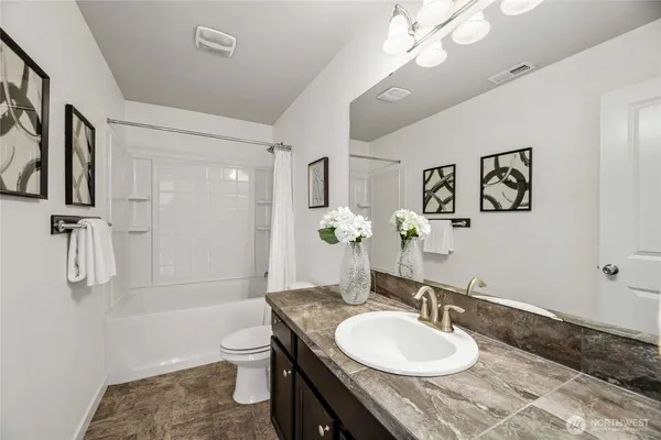 a bathroom with a granite countertop sink toilet and shower