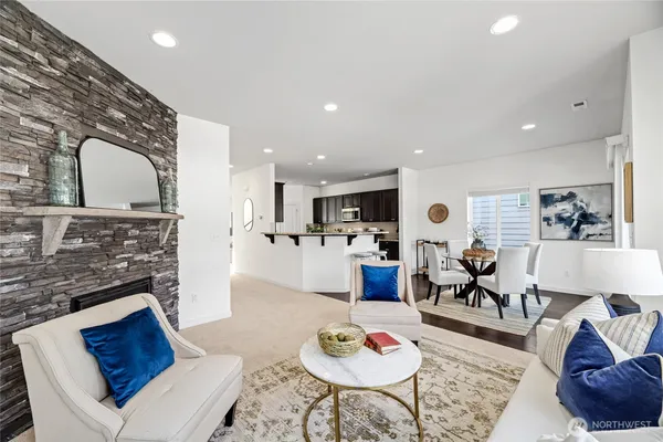 a living room with furniture kitchen view and a fireplace
