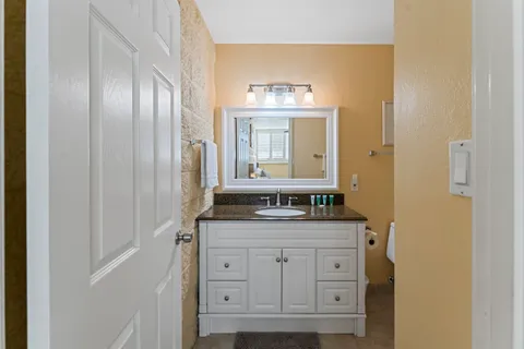 a bathroom with a granite countertop sink and a mirror