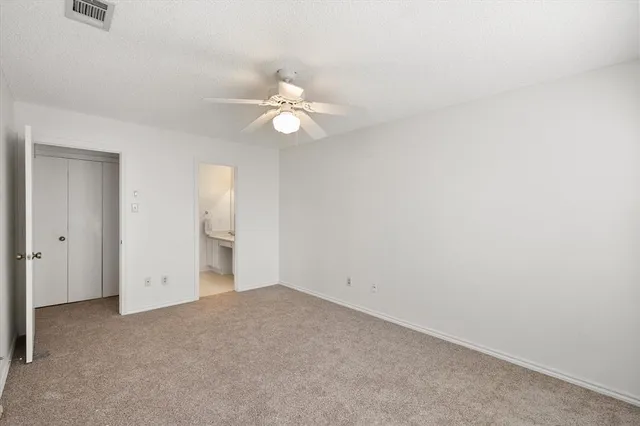 an empty room with a window and a ceiling fan