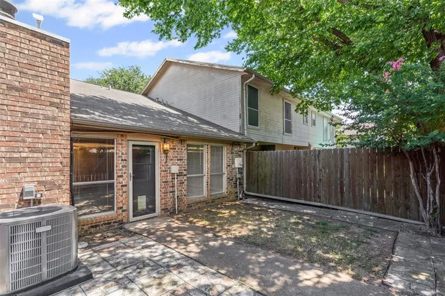 a view of a house with a backyard and wooden fence