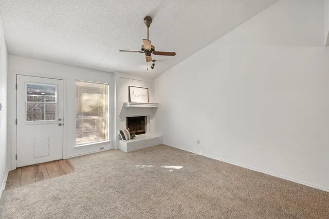 a view of an empty room with window and fireplace