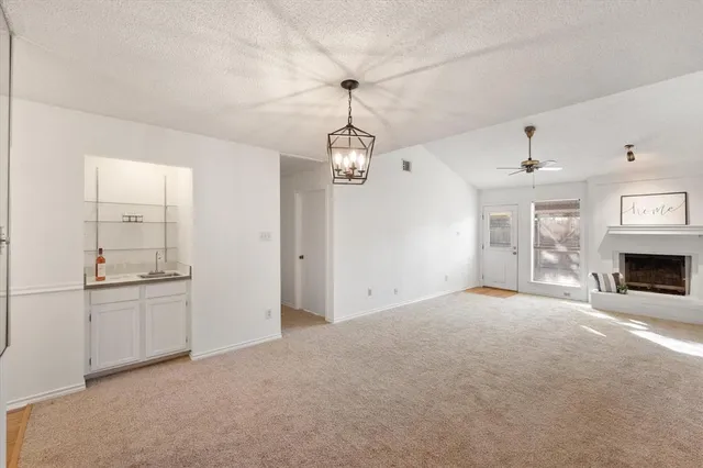 a view of an empty room with a fireplace and a window