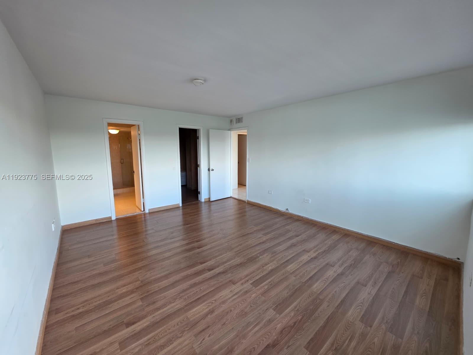 7135 Collins Avenue, Unit 725 Miami Beach, FL 33141 - Photo 12 of 21 a view of an empty room with wooden floor and a window