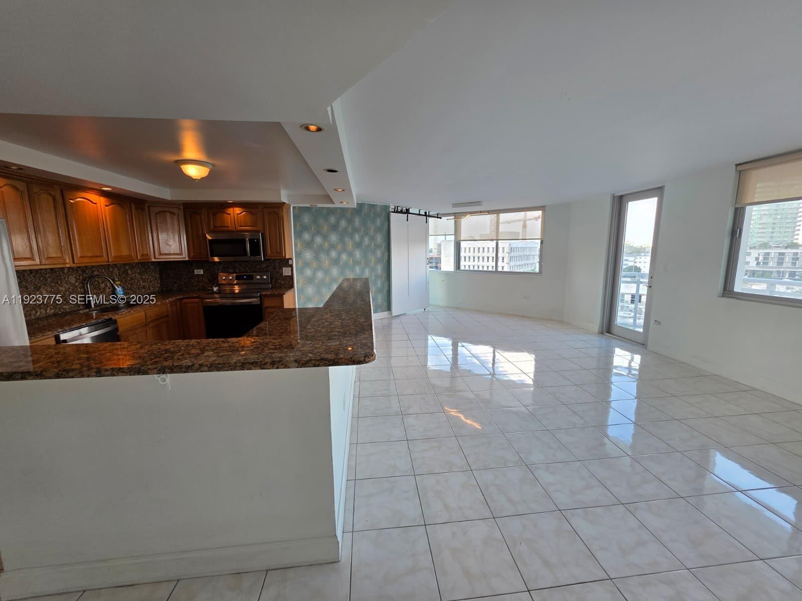 7135 Collins Avenue, Unit 725 Miami Beach, FL 33141 - Photo 8 of 21 a view of a kitchen with granite countertop a living room