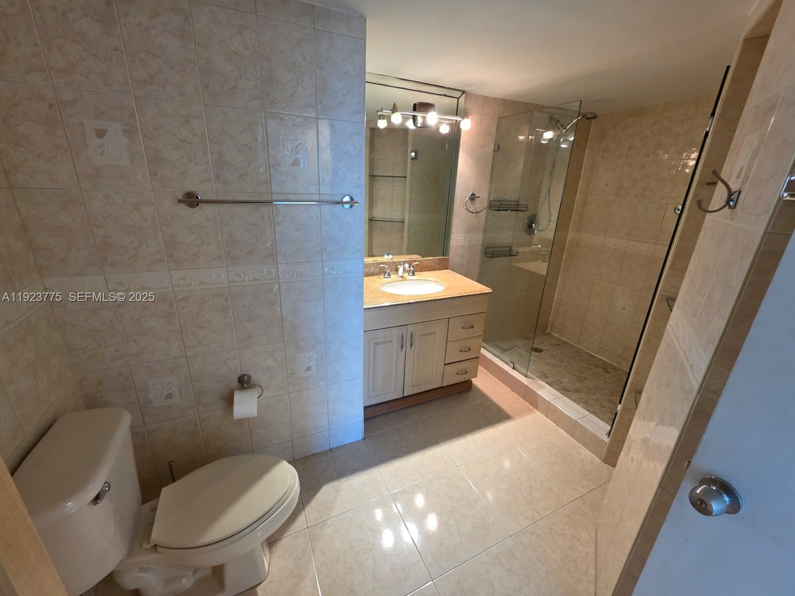 7135 Collins Avenue, Unit 725 Miami Beach, FL 33141 - Photo 10 of 21 a bathroom with a sink a toilet and shower