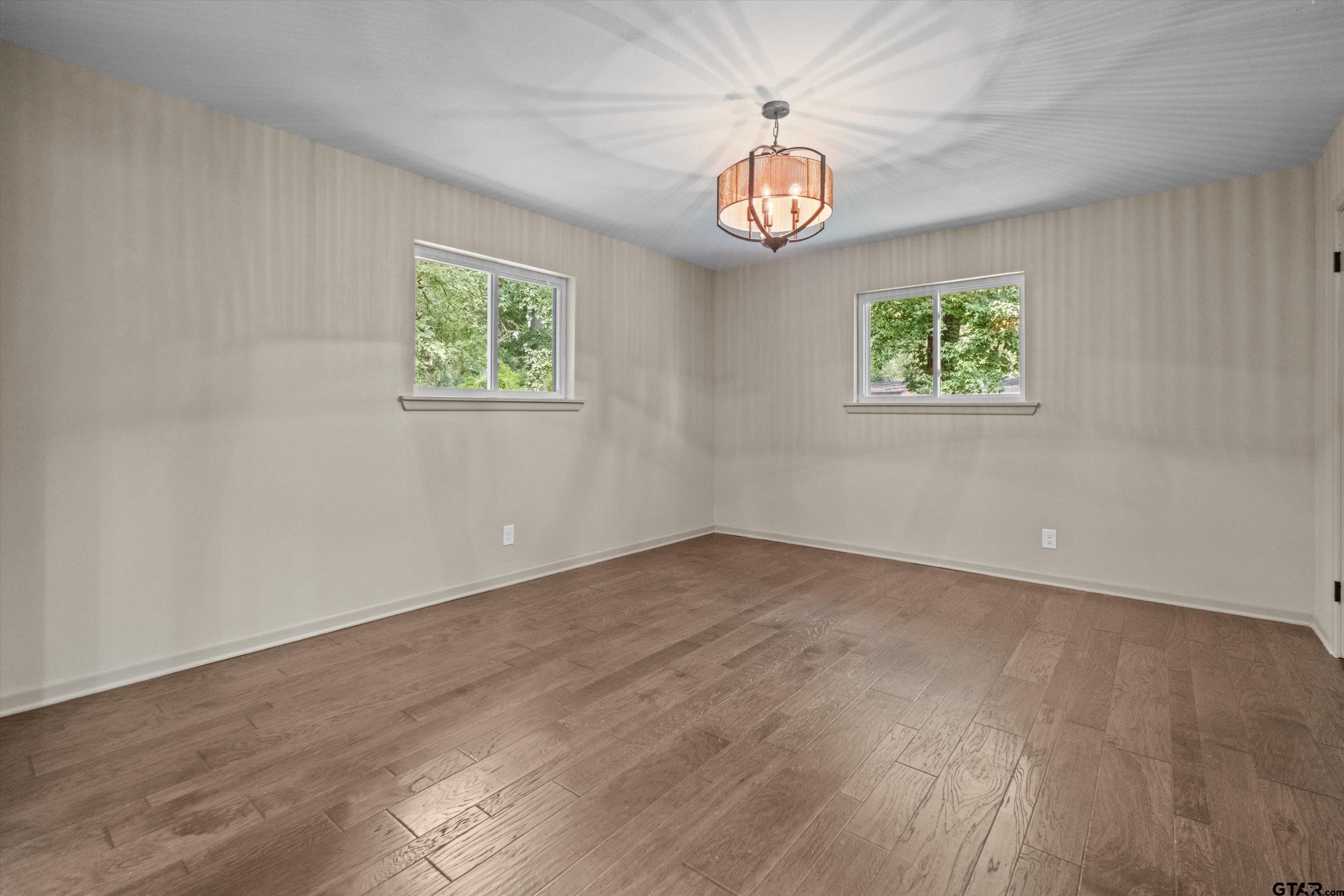 2515 Preston Avenue Tyler, TX 75701 - Photo 11 of 27 an empty room with wooden floor and windows