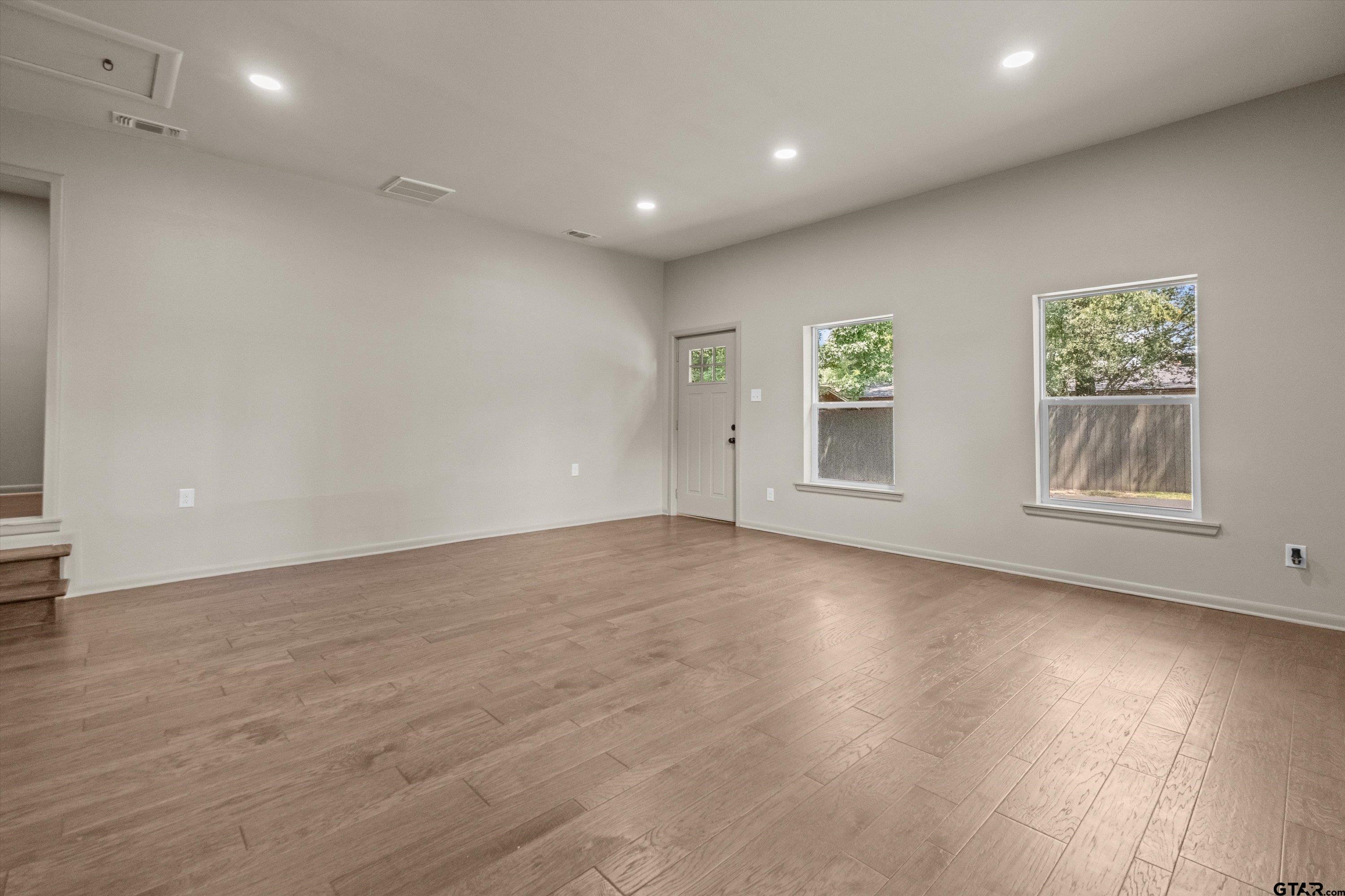 2515 Preston Avenue Tyler, TX 75701 - Photo 15 of 27 an empty room with wooden floor and windows