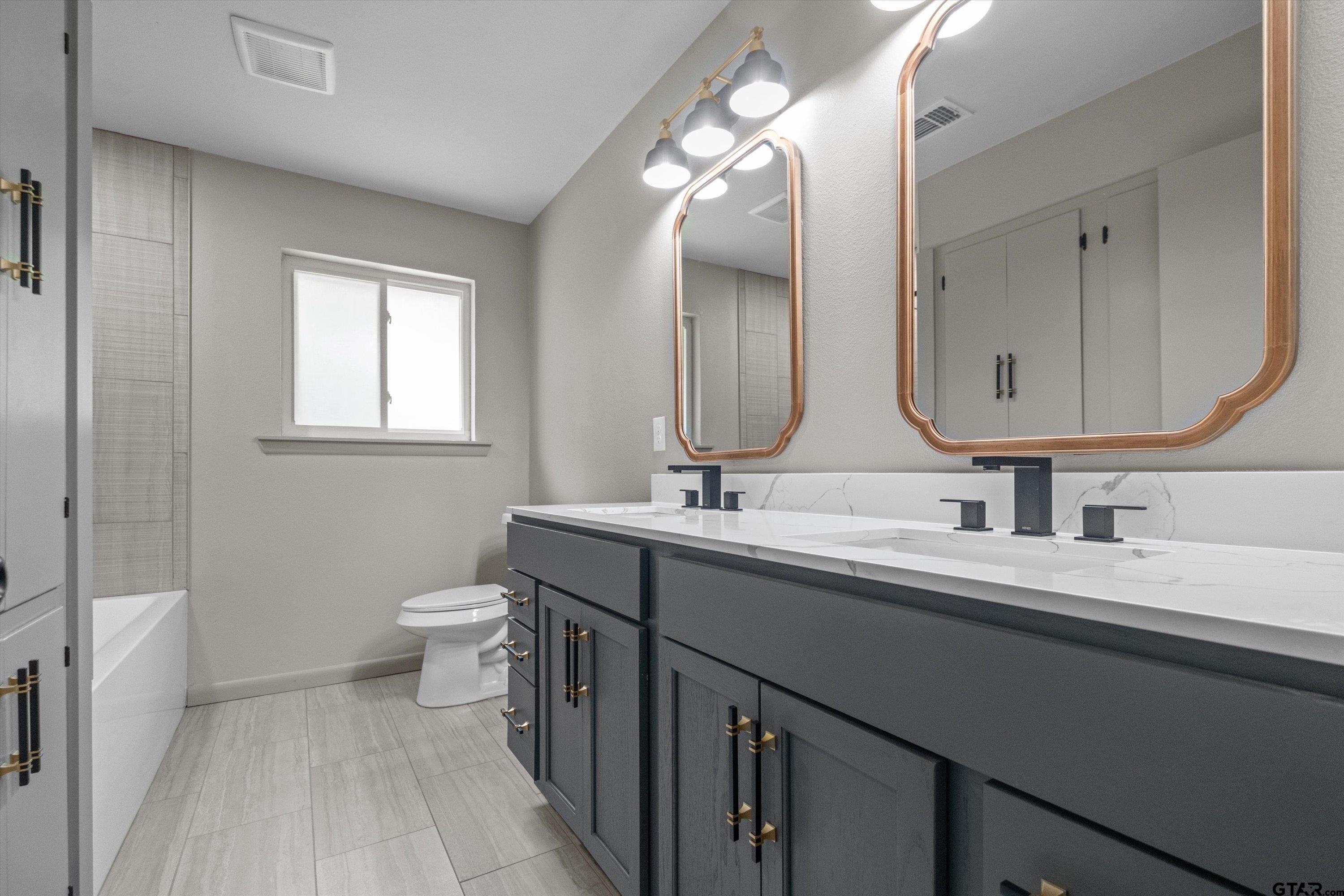 2515 Preston Avenue Tyler, TX 75701 - Photo 18 of 27 a bathroom with a double vanity sink and a mirror