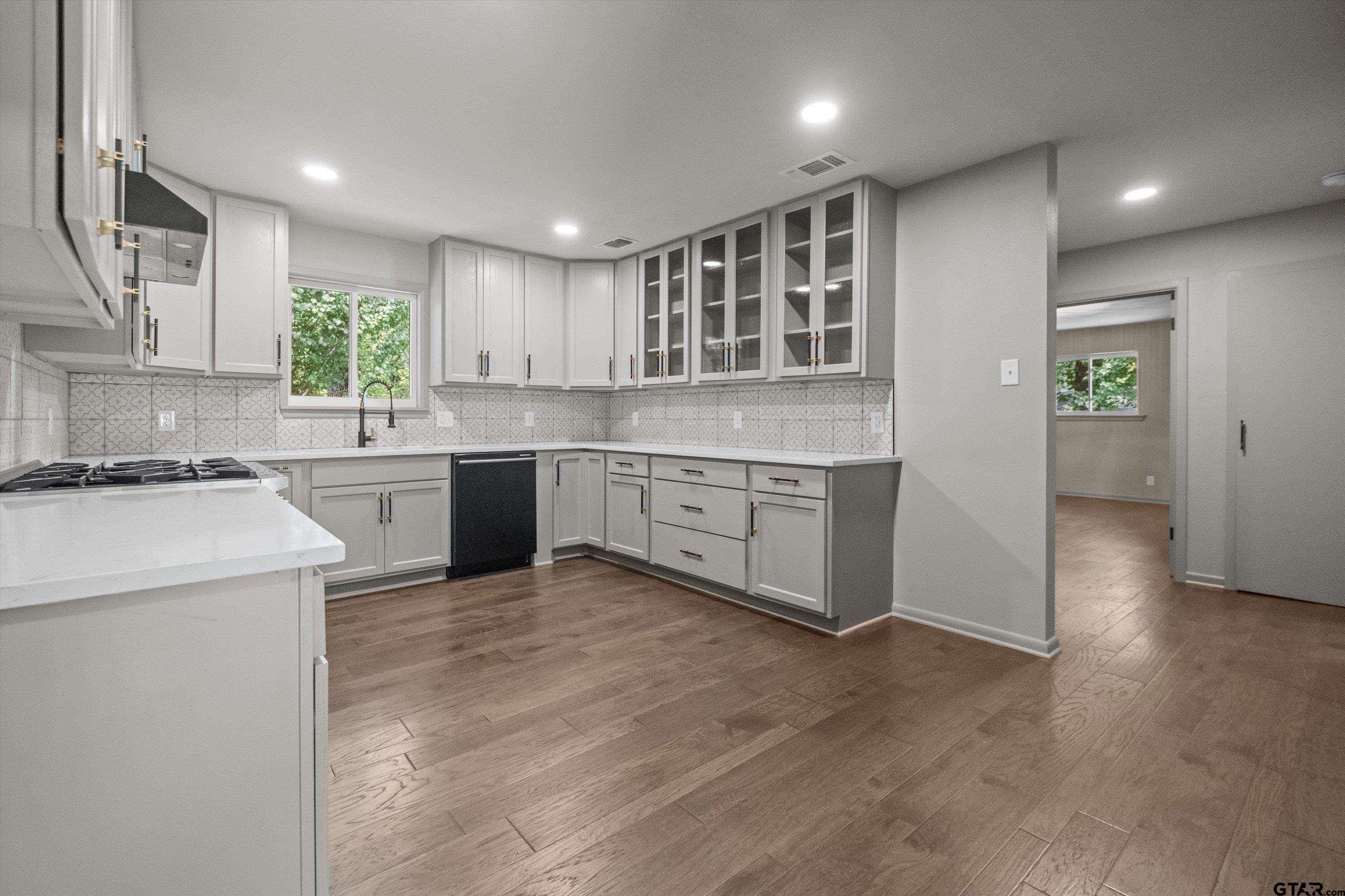 2515 Preston Avenue Tyler, TX 75701 - Photo 5 of 27 a large kitchen with stainless steel appliances granite countertop a stove a sink and a refrigerator