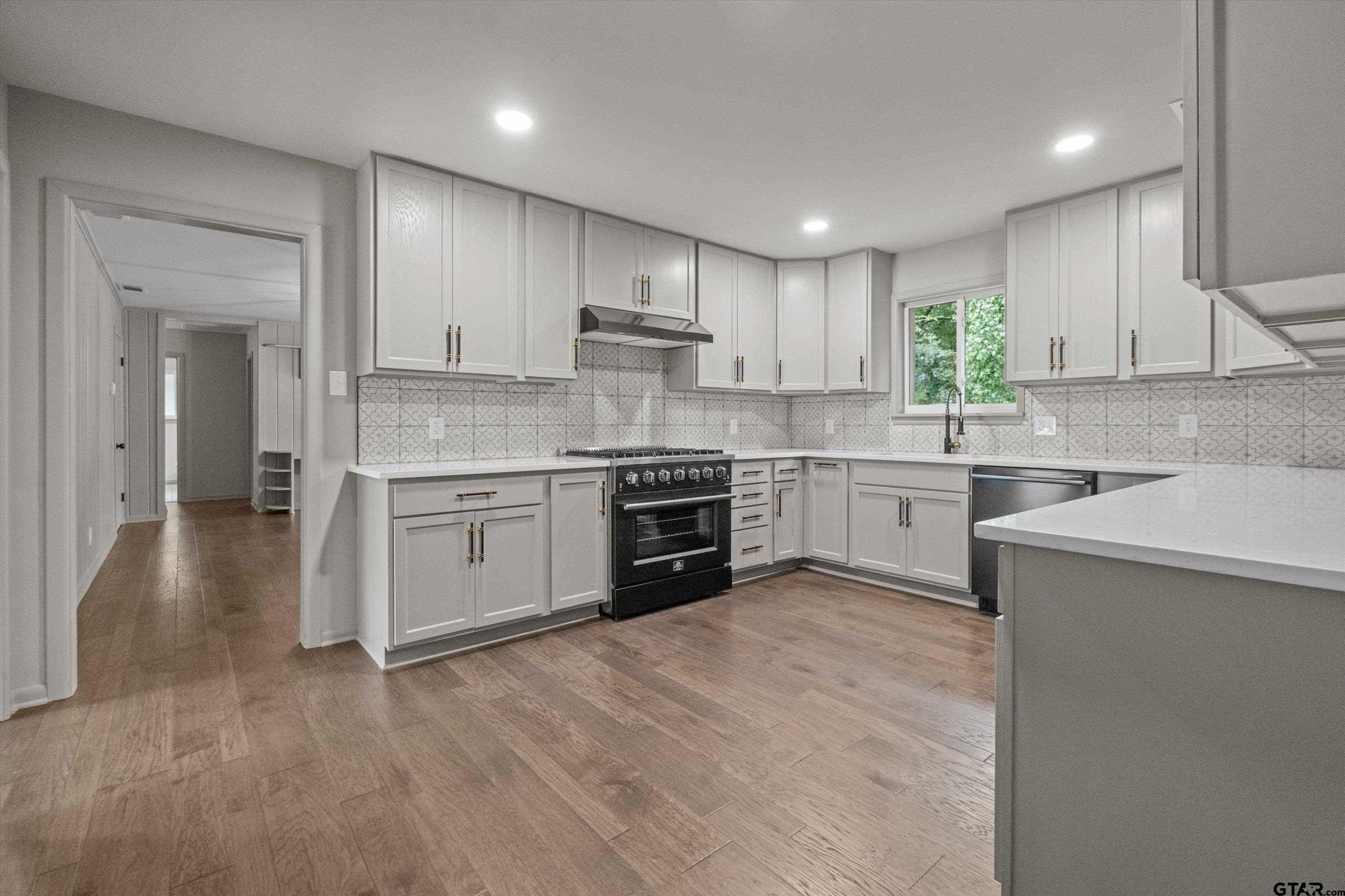 2515 Preston Avenue Tyler, TX 75701 - Photo 6 of 27 a kitchen with stainless steel appliances granite countertop a stove sink and cabinets