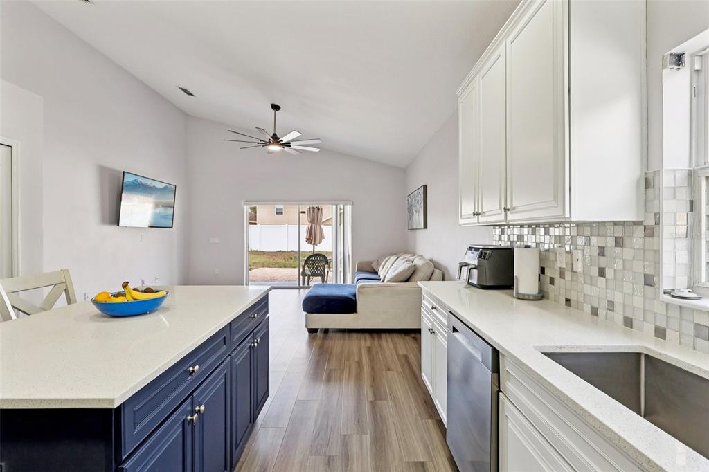 2104 Congress Lane St. Cloud, FL 34769 - Photo 13 of 71 a kitchen with a sink dishwasher a stove top oven a dining table with chairs and cabinets