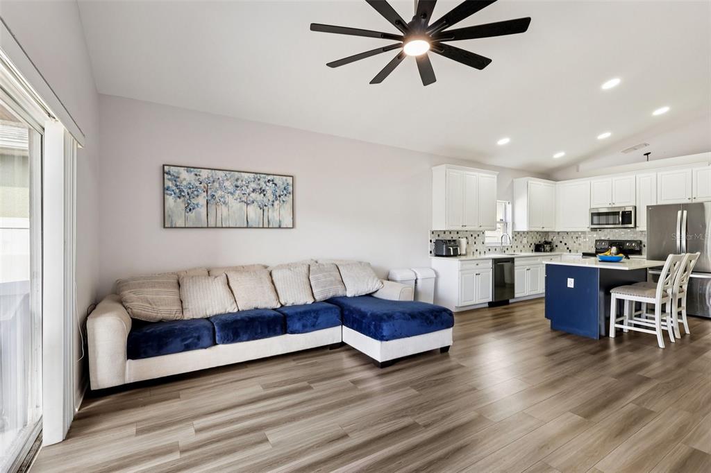 2104 Congress Lane St. Cloud, FL 34769 - Photo 15 of 71 a living room with stainless steel appliances kitchen island granite countertop furniture and a wooden floor