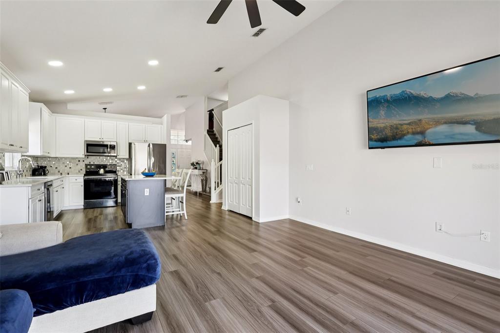 2104 Congress Lane St. Cloud, FL 34769 - Photo 16 of 71 a large living room with stainless steel appliances kitchen island granite countertop furniture and a view of kitchen