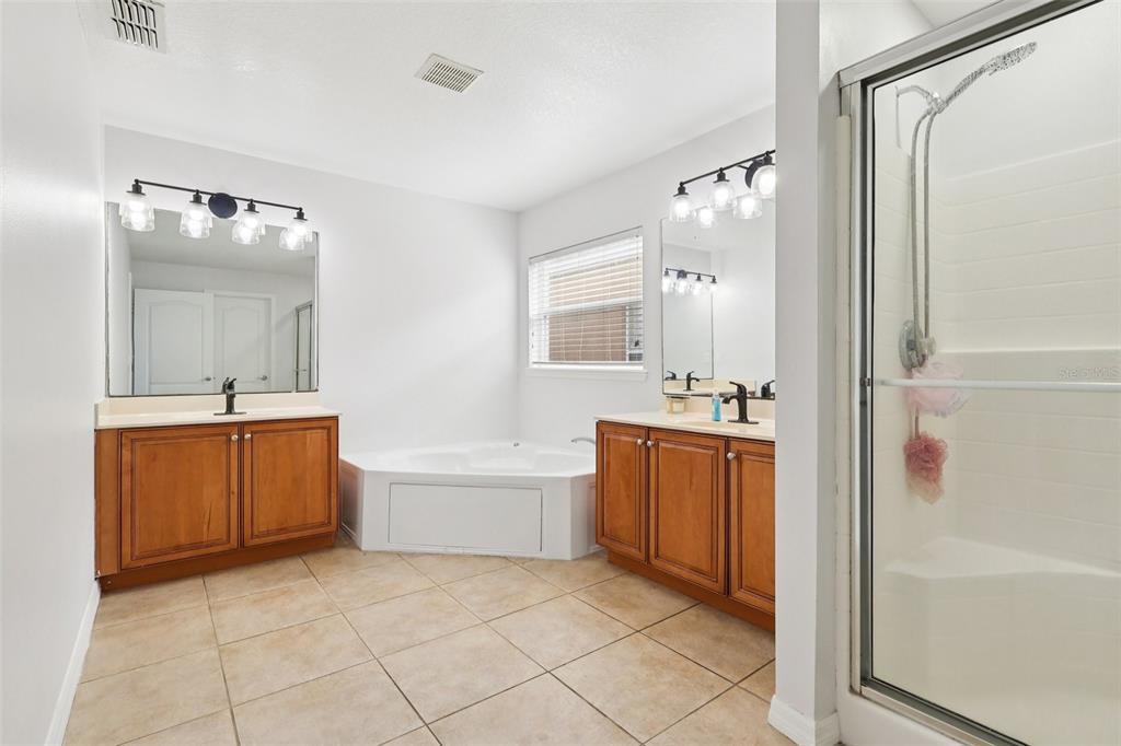 2104 Congress Lane St. Cloud, FL 34769 - Photo 20 of 71 a bathroom with a tub sink and mirror