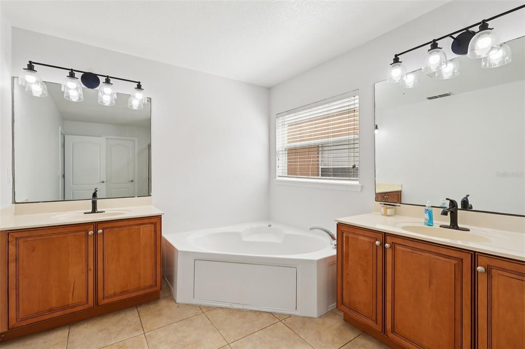 2104 Congress Lane St. Cloud, FL 34769 - Photo 21 of 71 a bathroom with a tub sink and mirror