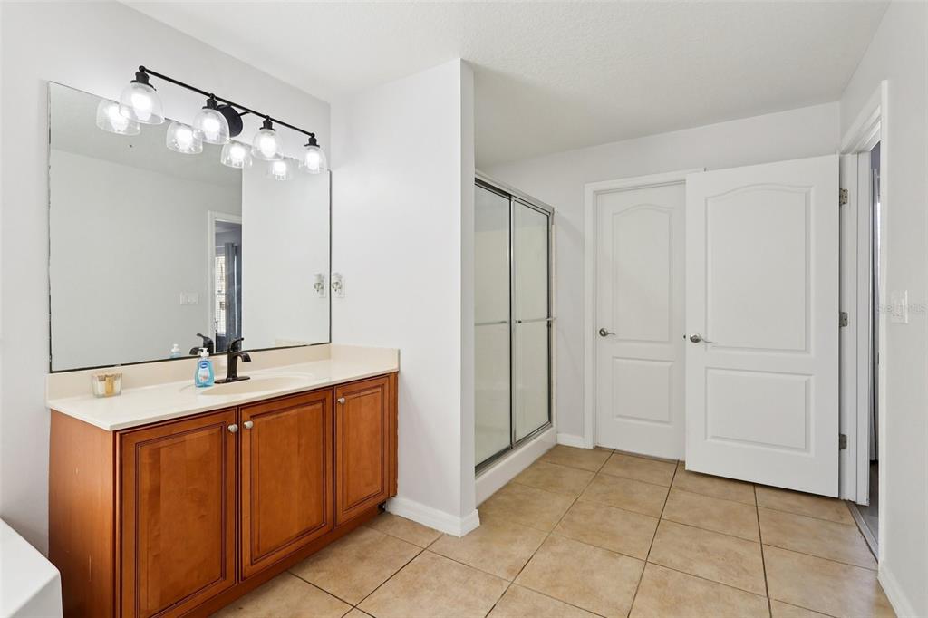 2104 Congress Lane St. Cloud, FL 34769 - Photo 22 of 71 a bathroom with a sink mirror and a shower