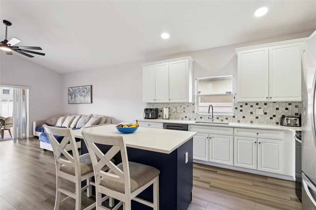 2104 Congress Lane St. Cloud, FL 34769 - Photo 9 of 71 a kitchen with granite countertop white cabinets and chairs