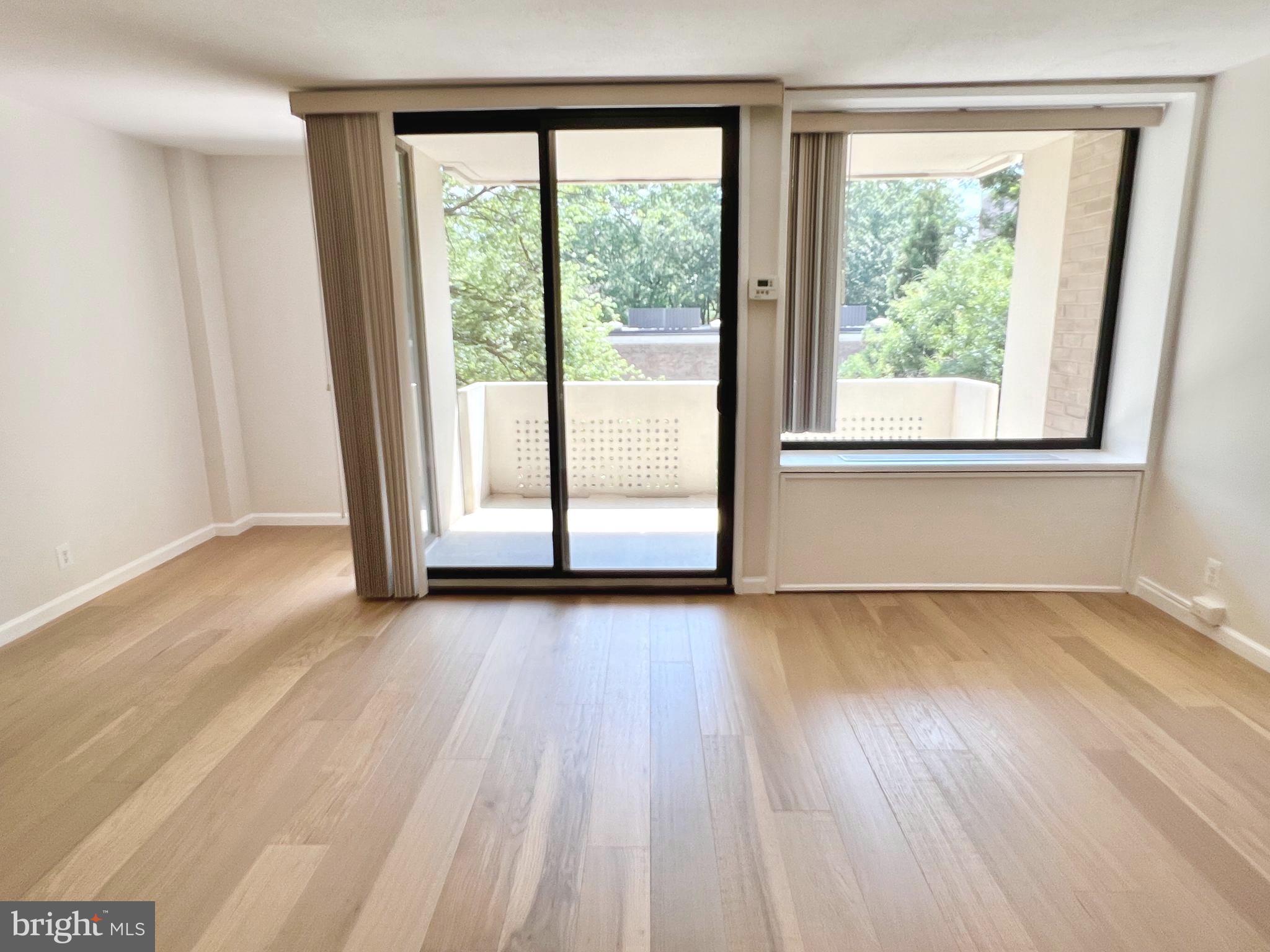 430 M Street Southwest, Unit N203 Washington, DC 20024 - Photo 3 of 5 a view of an empty room with wooden floor and a window