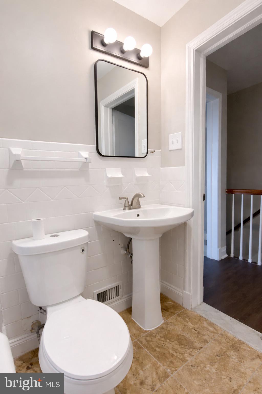 3582 Dudley Avenue Baltimore, MD 21213 - Photo 5 of 12 a bathroom with a toilet sink and mirror