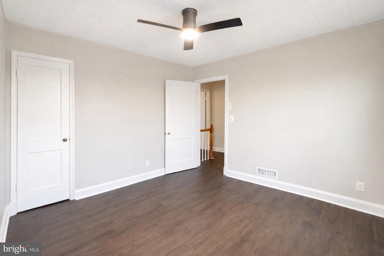 3582 Dudley Avenue Baltimore, MD 21213 - Photo 8 of 12 an empty room with wooden floor ceiling fan and window