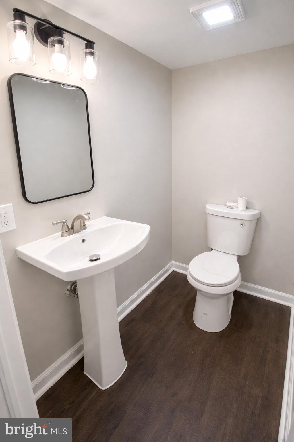 3582 Dudley Avenue Baltimore, MD 21213 - Photo 10 of 12 a bathroom with a toilet sink and mirror