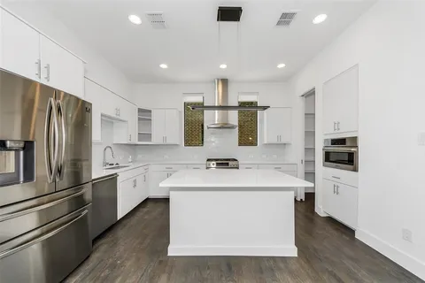 a kitchen with a stove sink and cabinets