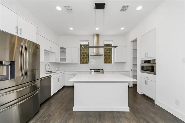 a kitchen with a stove sink and cabinets