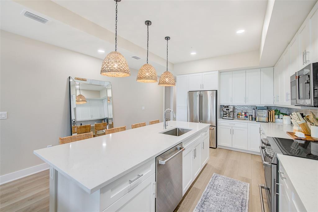 400 150th Avenue, Unit 504 Madeira Beach, FL 33708 - Photo 13 of 60 a kitchen with a sink a counter top space stainless steel appliances and cabinets