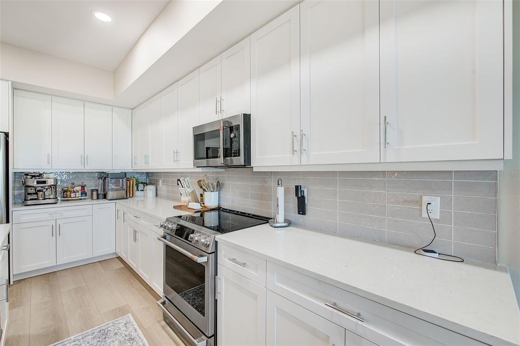400 150th Avenue, Unit 504 Madeira Beach, FL 33708 - Photo 15 of 60 a kitchen with white cabinets and white appliances