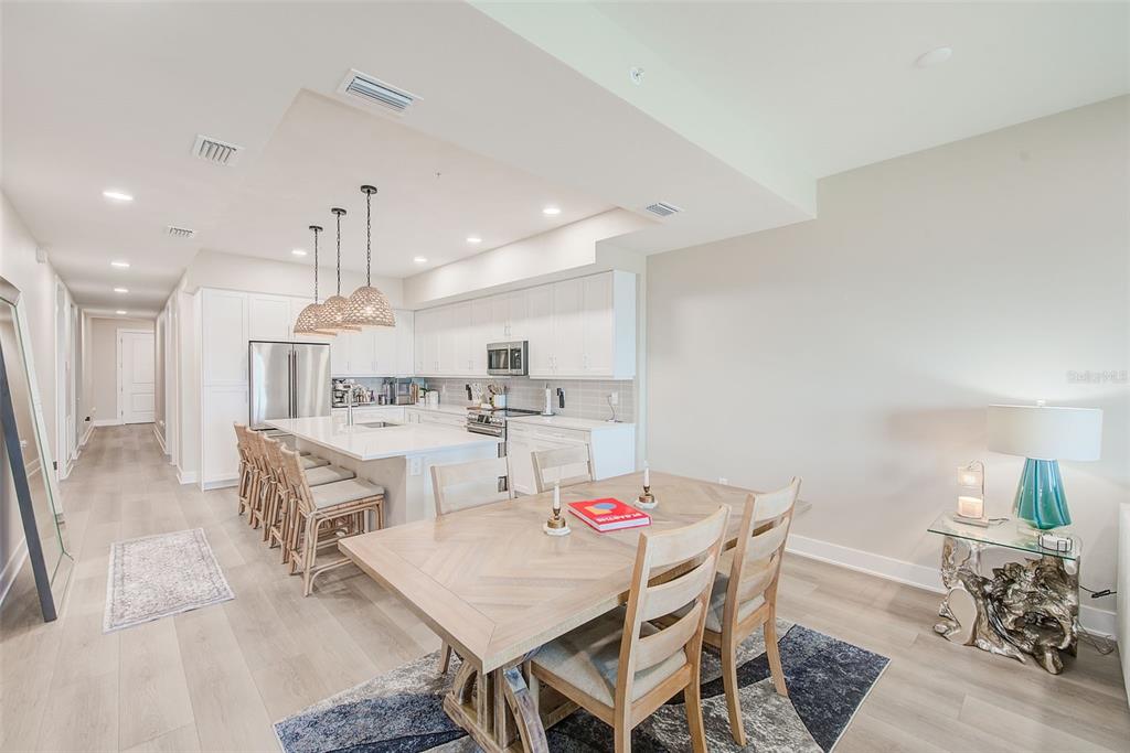 400 150th Avenue, Unit 504 Madeira Beach, FL 33708 - Photo 18 of 60 a dining room with kitchen island stainless steel appliances furniture a dining table and chairs