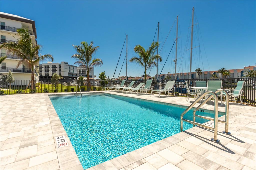 400 150th Avenue, Unit 504 Madeira Beach, FL 33708 - Photo 31 of 60 a swimming pool with outdoor seating and yard