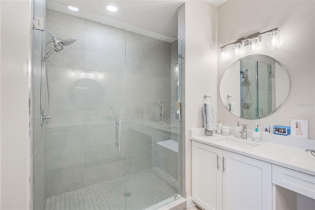 400 150th Avenue, Unit 504 Madeira Beach, FL 33708 - Photo 40 of 60 a bathroom with a double vanity sink mirror double shower and a mirror