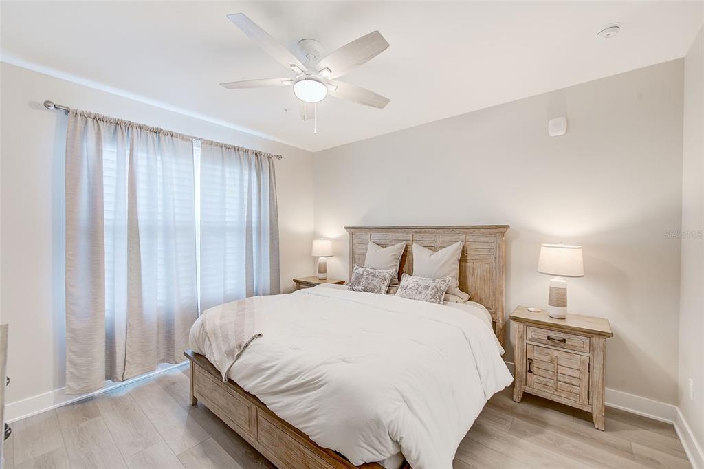 400 150th Avenue, Unit 504 Madeira Beach, FL 33708 - Photo 41 of 60 a large bed sitting in a bedroom next to a window and a chandelier