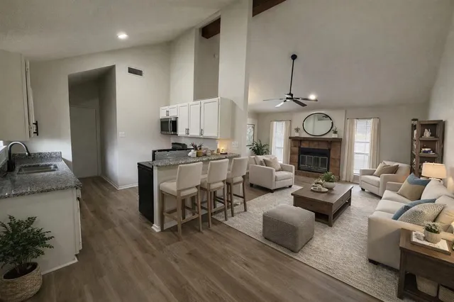 a living room with furniture a fireplace and a flat screen tv