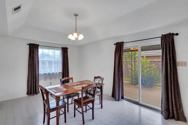 a dining room with furniture a chandelier and window