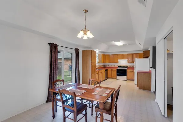 a view of a dining room with furniture and chandelier