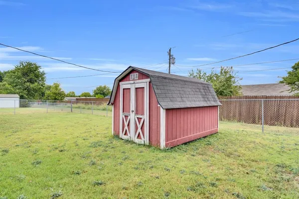 a view of a backyard with wooden fence