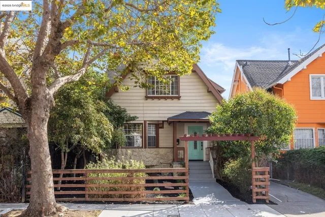 a front view of a house with a tree