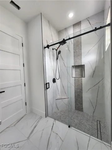 a bathroom with a glass shower door and mirror