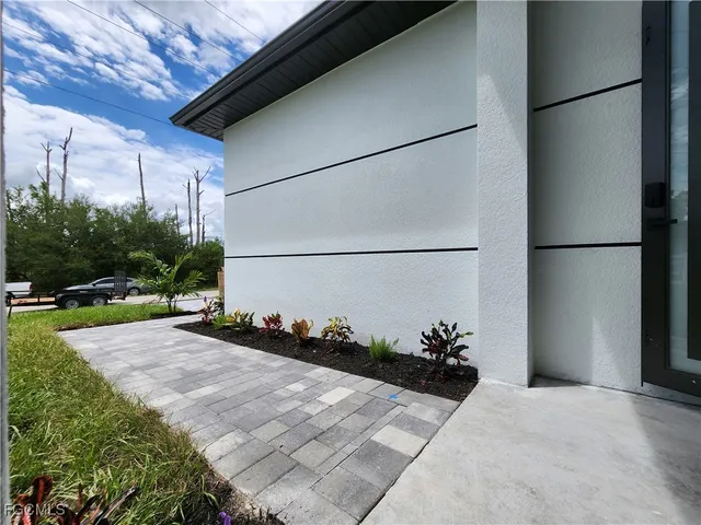 a large white kitchen with a large window and stainless steel appliances