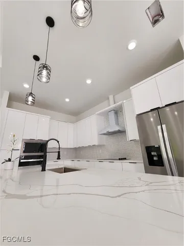 a large kitchen with stainless steel appliances kitchen island granite countertop a sink and cabinets