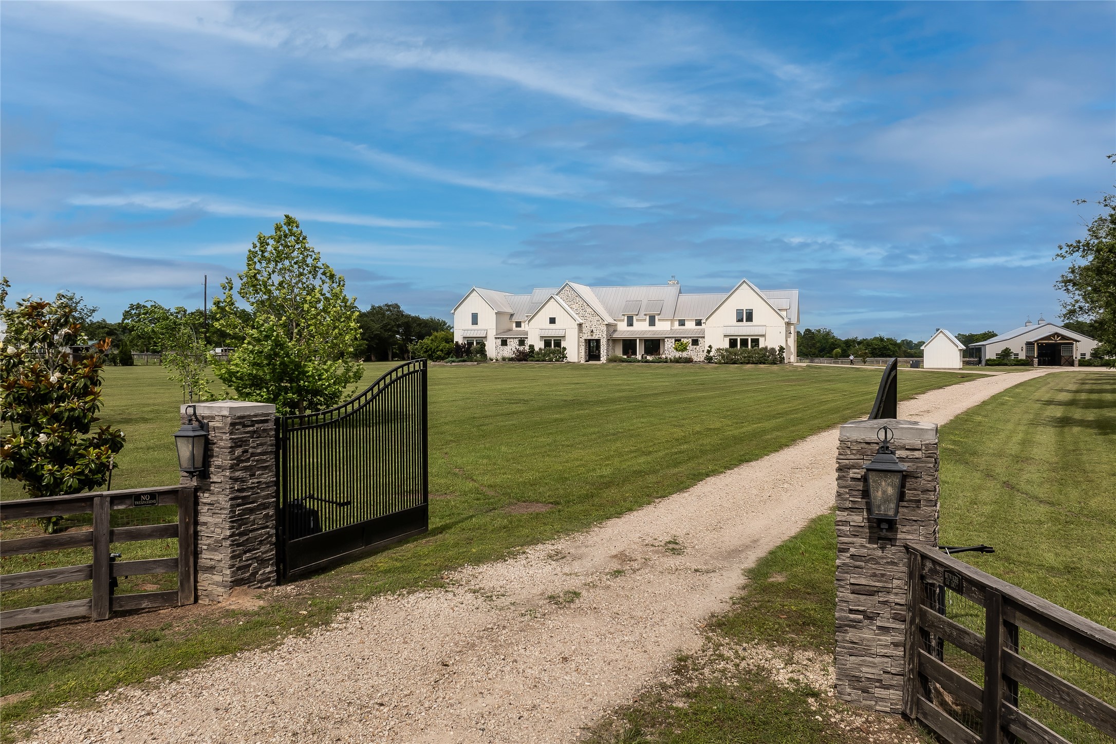 24118 Margerstadt Road Hockley, TX 77447 - Photo 4 of 46 Commercial grade gate systems, fenced pasture, and long approach views establish the scale and privacy of the estate upon arrival. Positioned across 19 AG exempt acres, the property combines open land with thoughtfully integrated infrastructure throughout.