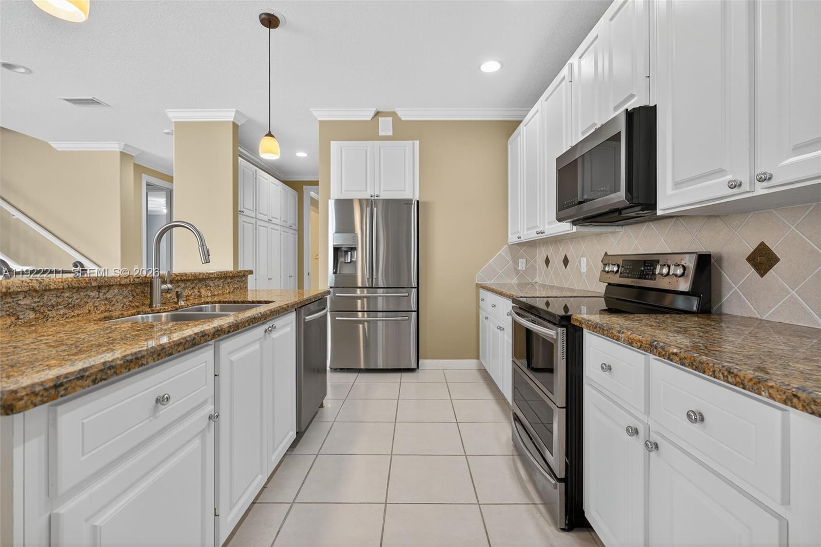 3518 Community Drive Jupiter, FL 33458 - Photo 12 of 38 a large kitchen with stainless steel appliances granite countertop a sink a stove top oven and granite counter tops