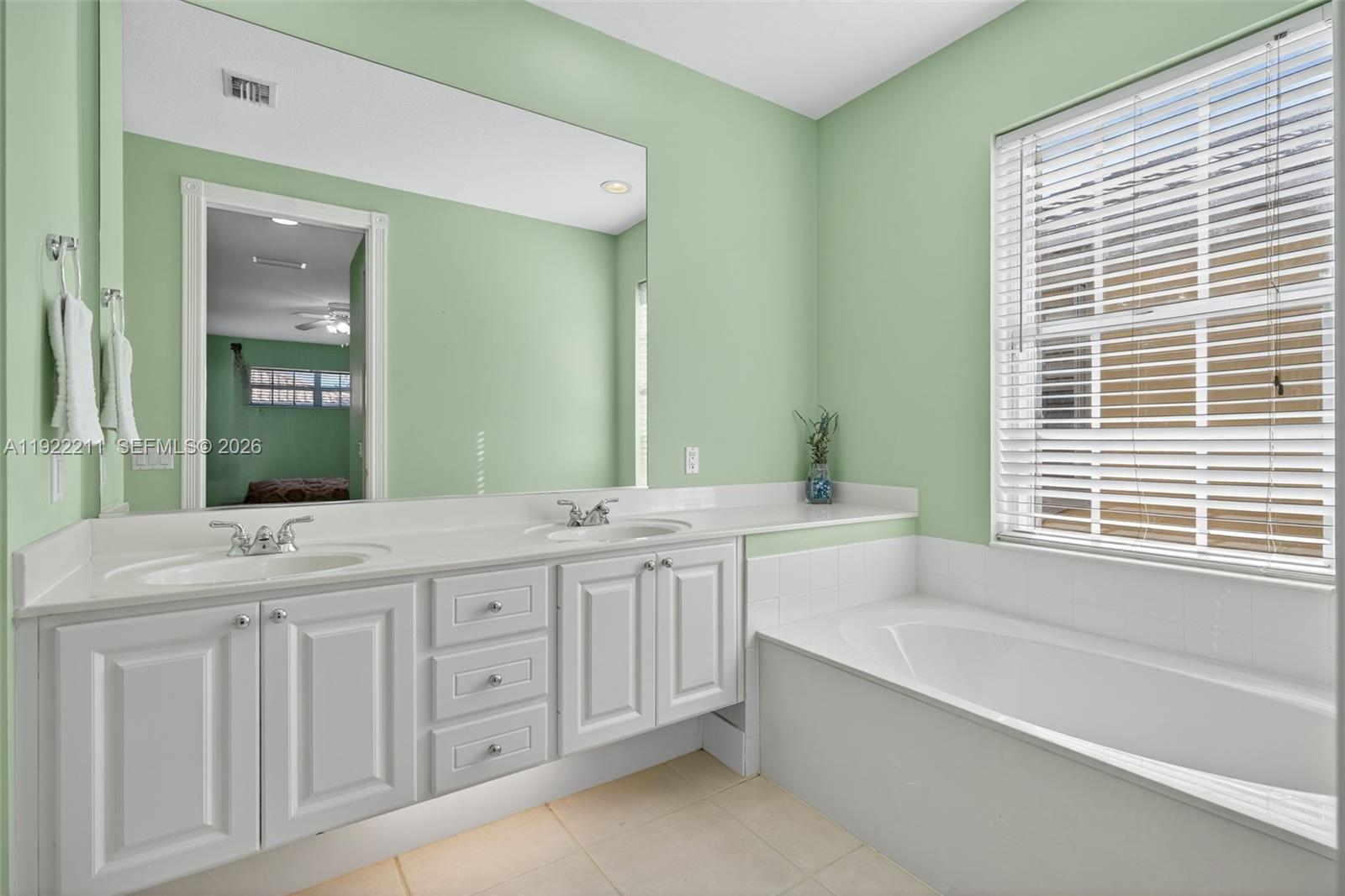 3518 Community Drive Jupiter, FL 33458 - Photo 17 of 38 a spacious bathroom with a granite countertop tub sink and mirror