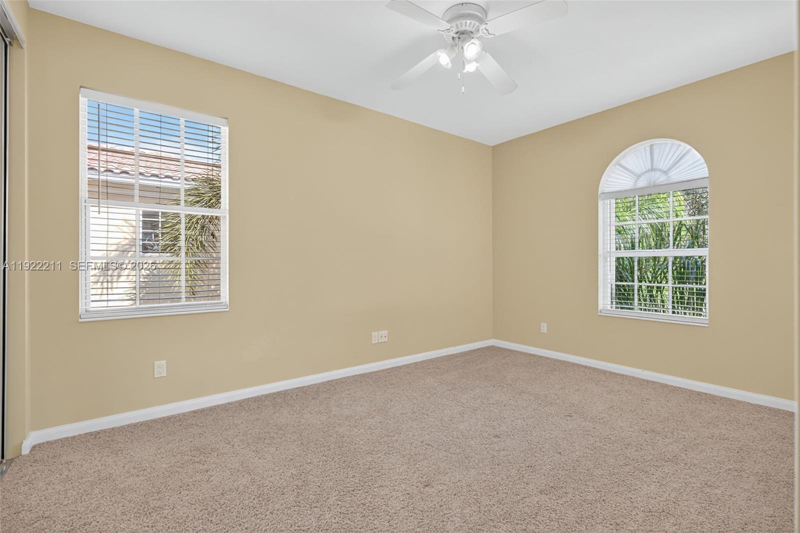 3518 Community Drive Jupiter, FL 33458 - Photo 23 of 38 an empty room with windows and chandelier fan