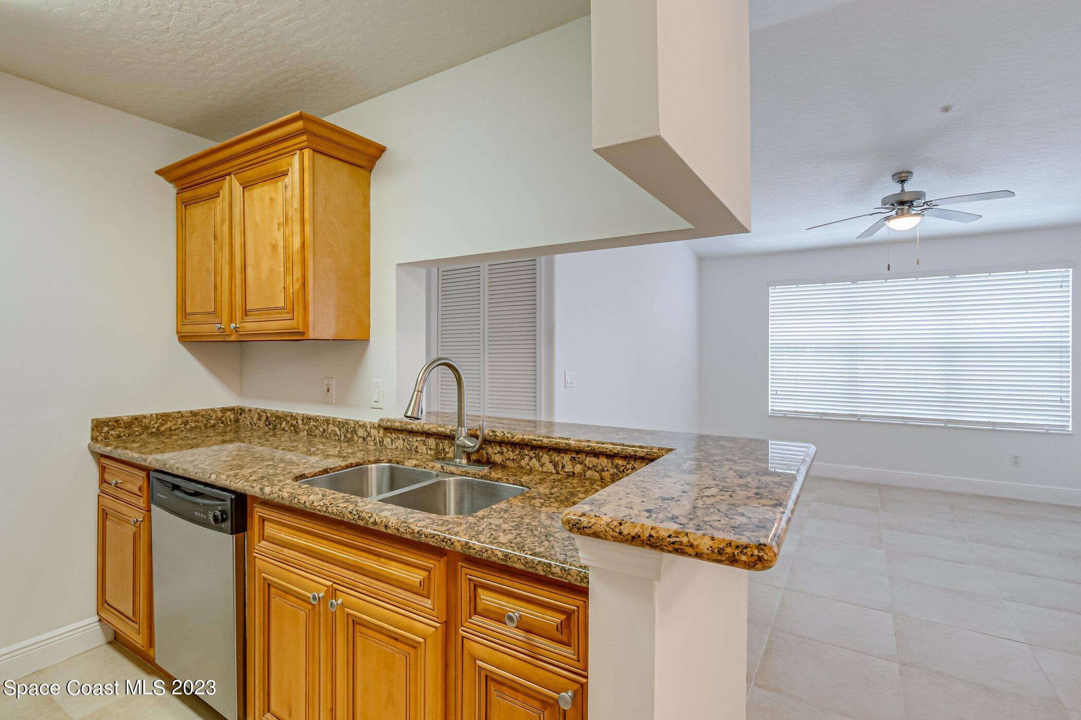 7667 North Wickham Road, Unit 617 Melbourne, FL 32940 - Photo 17 of 44 a kitchen with granite countertop sink and cabinets