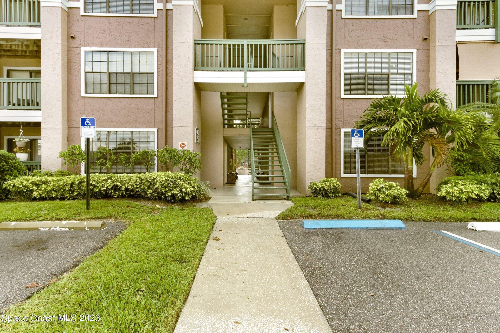 7667 North Wickham Road, Unit 617 Melbourne, FL 32940 - Photo 43 of 44 front view of a brick house with a yard