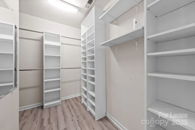 a view of walk in closet with empty racks