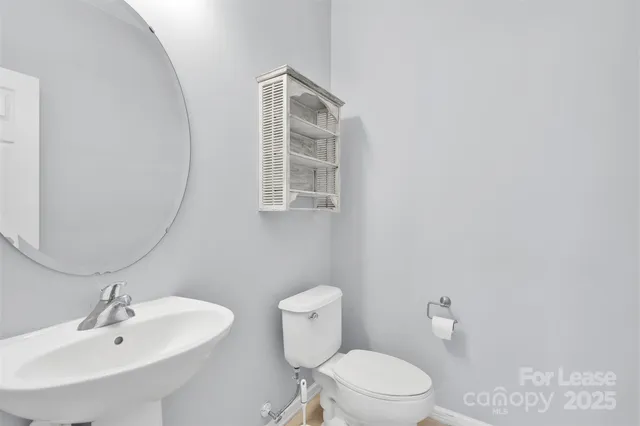 a bathroom with a sink a toilet and mirror